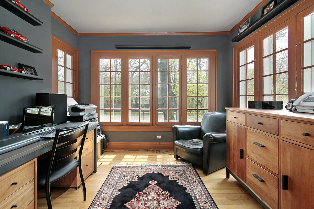 a home office with a lot of windows bringing in natural light