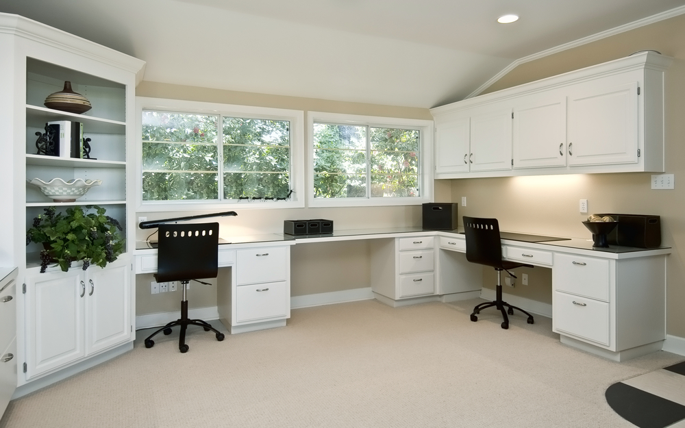 a home office with lots of shelf space and drawers for storage