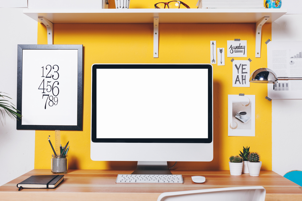 a home office with the wall behind the computer painted yellow