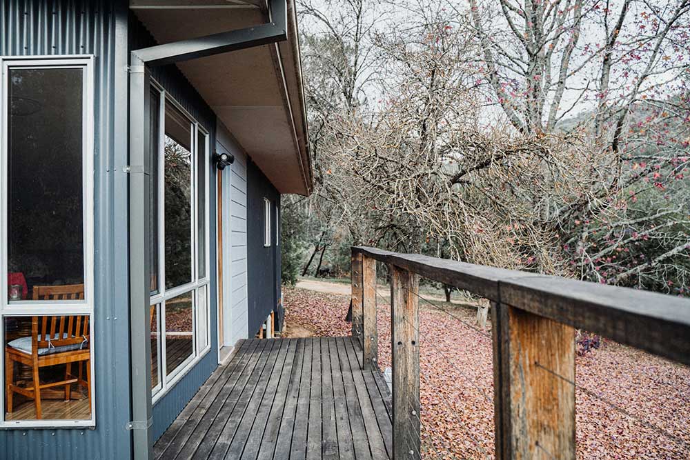 Wooden deck connected to a blue-gray house