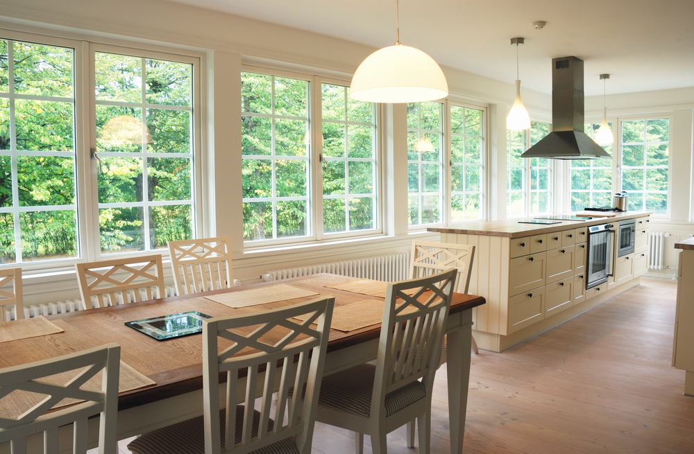 a kitchen and dining room with sunlight coming in many windows on the walls