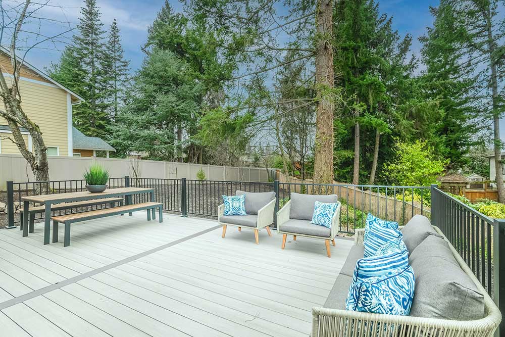 A light-colored wooden deck with a gray railing