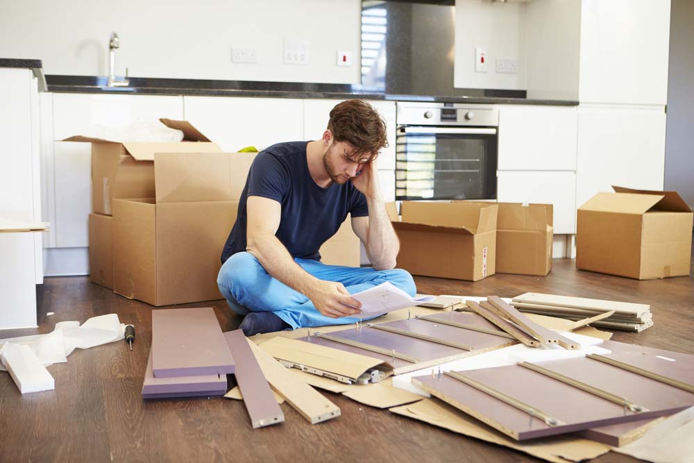 a man reading the instructions for assembling furniture